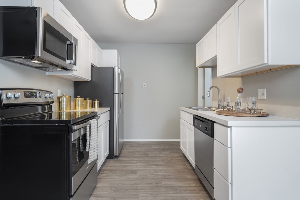 a kitchen with white cabinets and black appliances