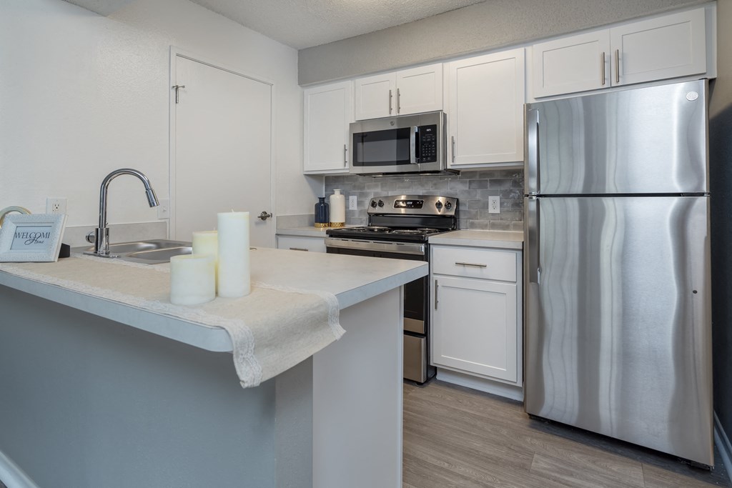 a kitchen with stainless steel appliances and white cabinets