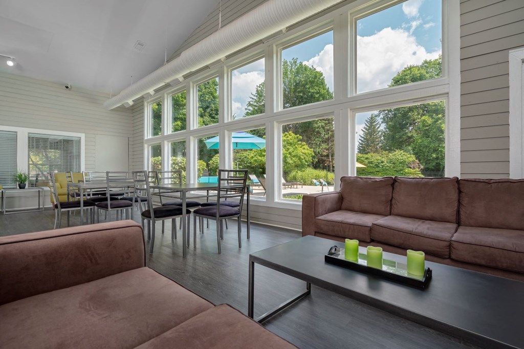 a living room with couches and a coffee table and large windows