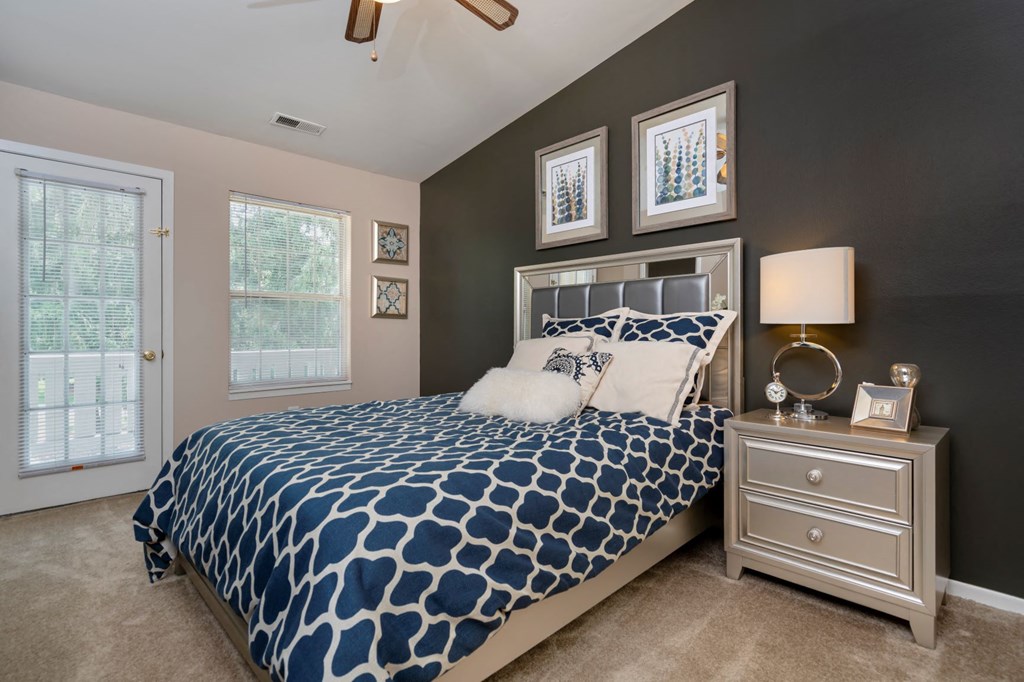 a blue and white bed in a bedroom with brown walls