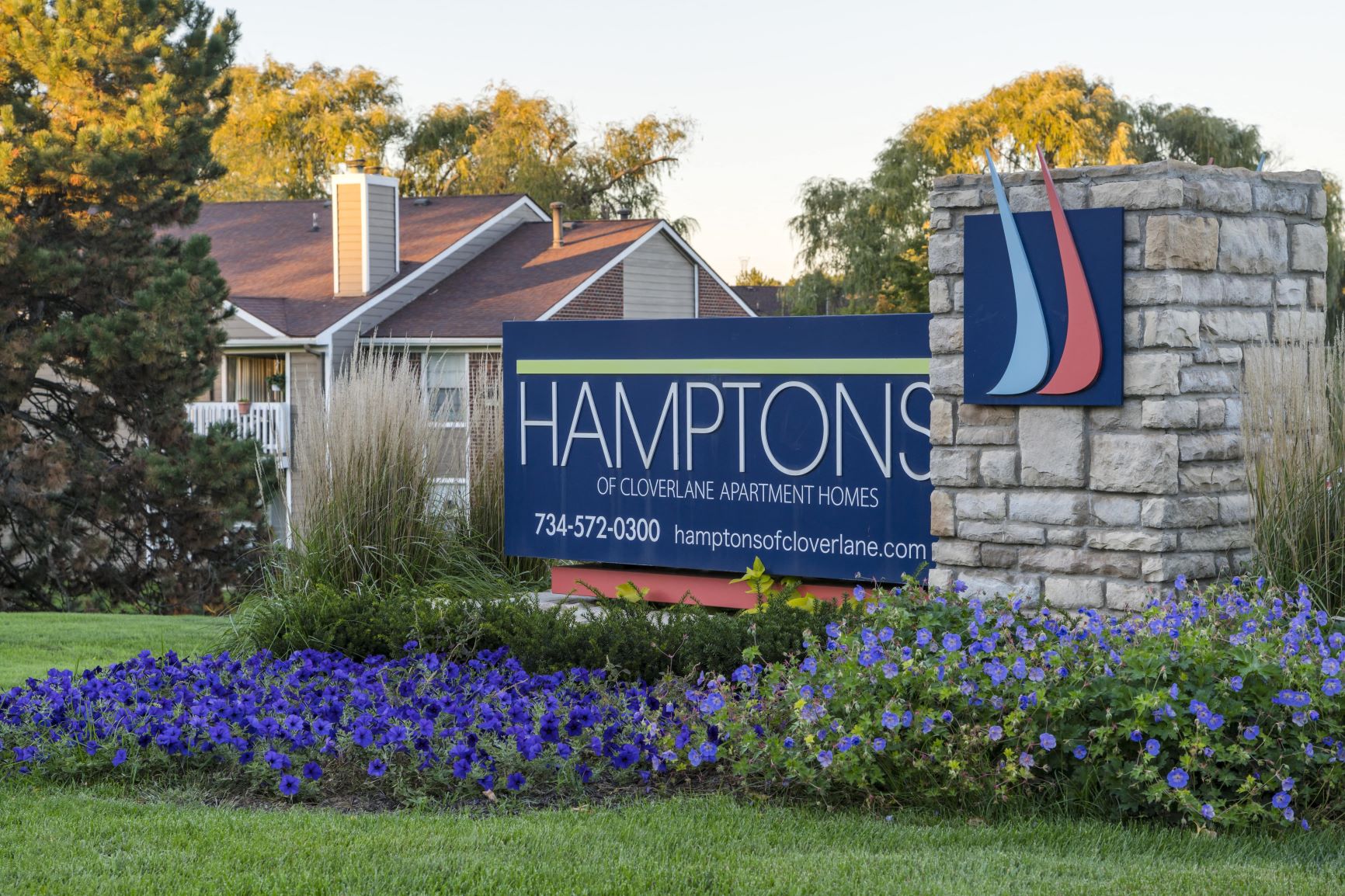 a sign for hamptons gardening and residential park in front of a house