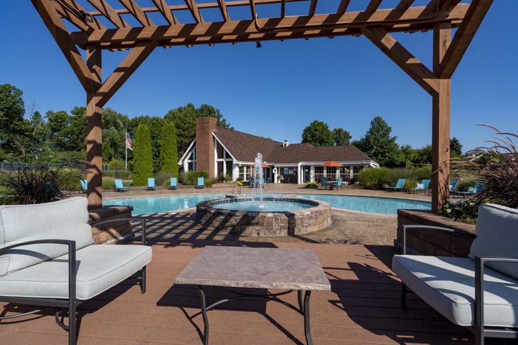 a backyard with a pool and patio with chairs and a table