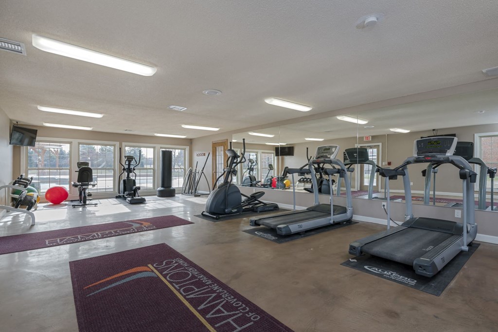 a gym with weights and cardio equipment at the enclave at university crossings apartments