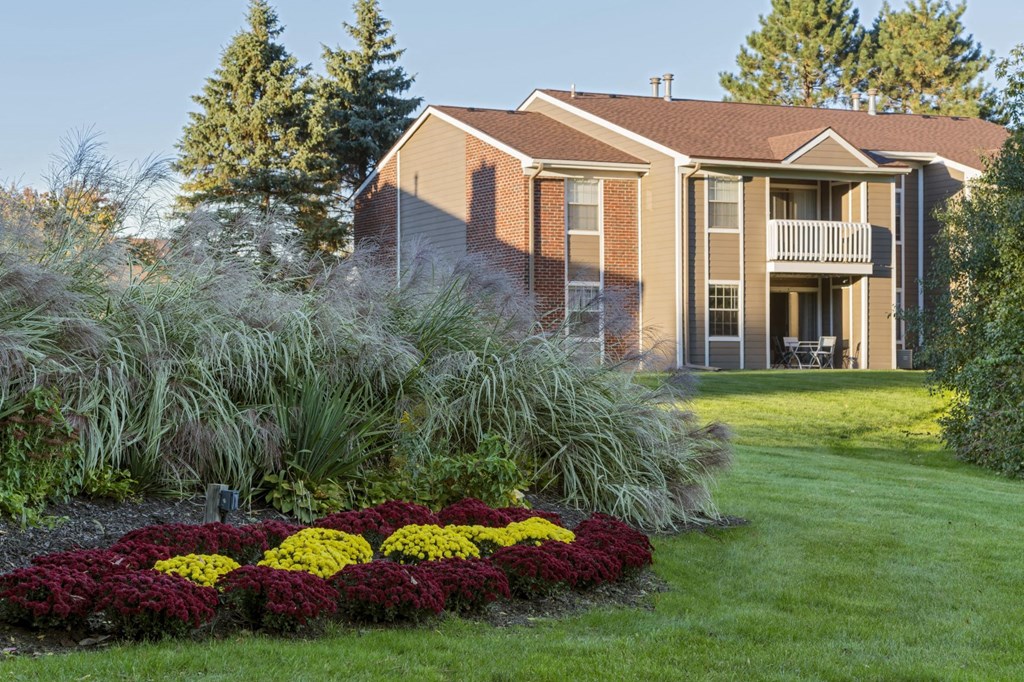 a house with a lawn and flowers in front of it