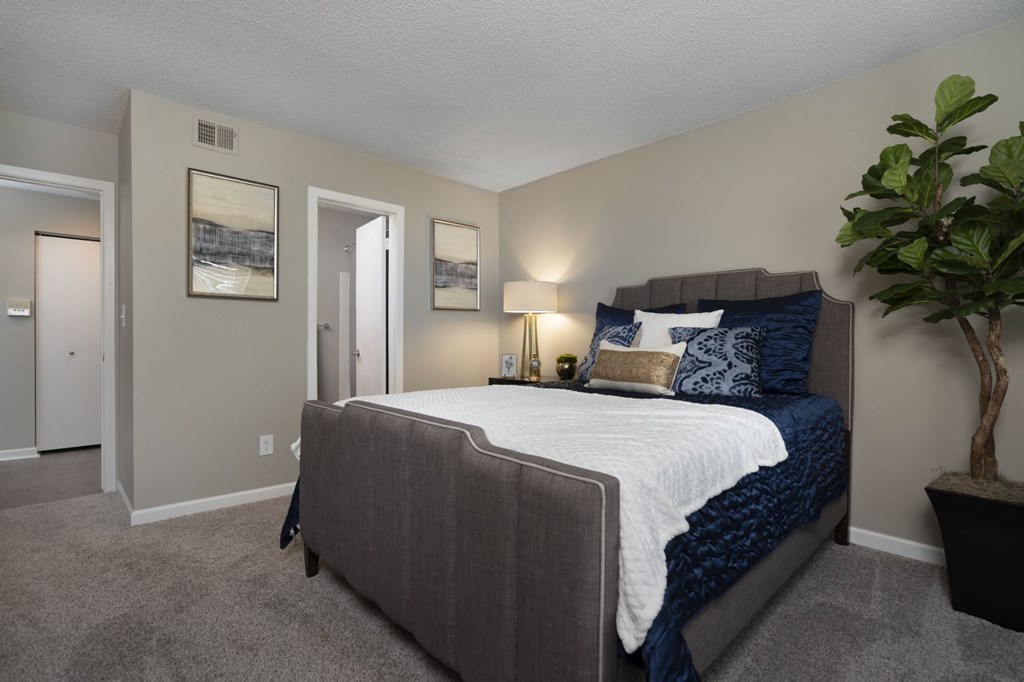 a bedroom with a bed and a plant