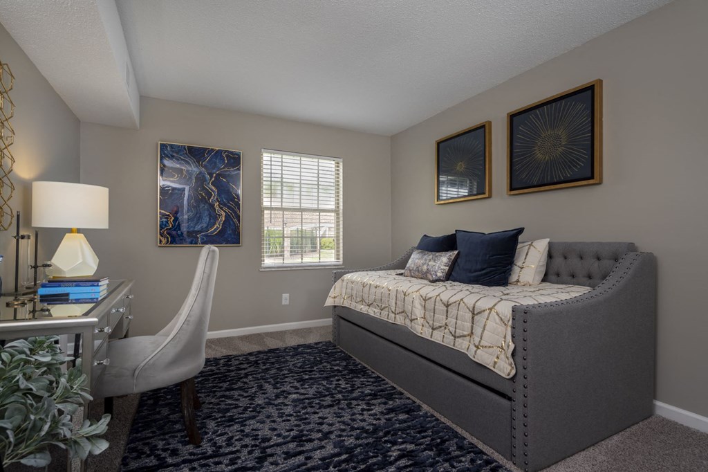 a bedroom with a bed and a desk with a chair