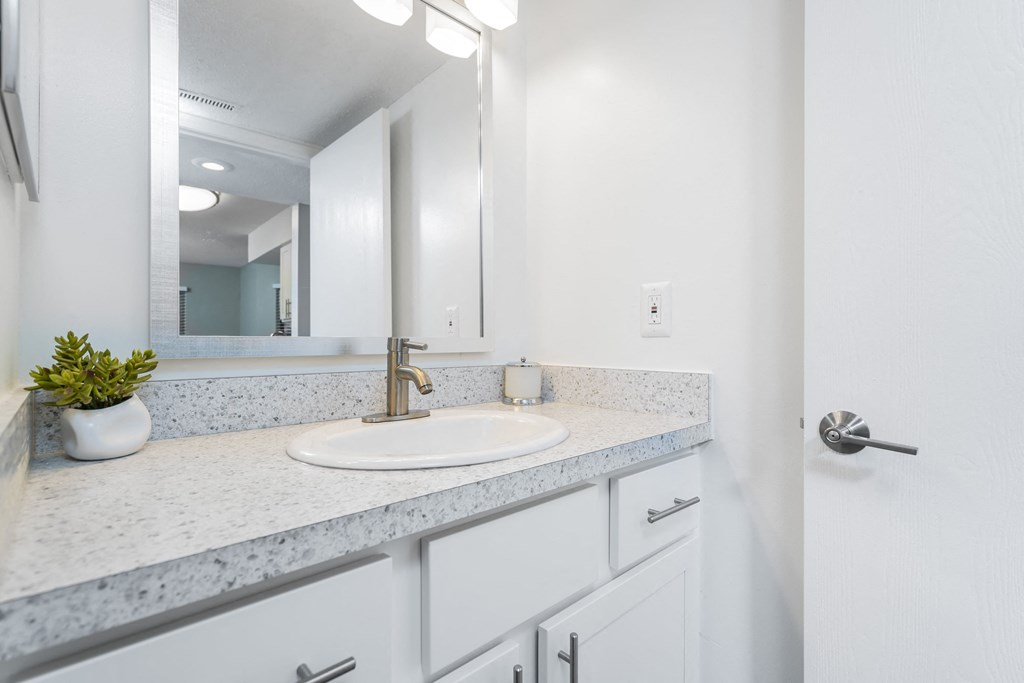 a white bathroom with a sink and a mirror