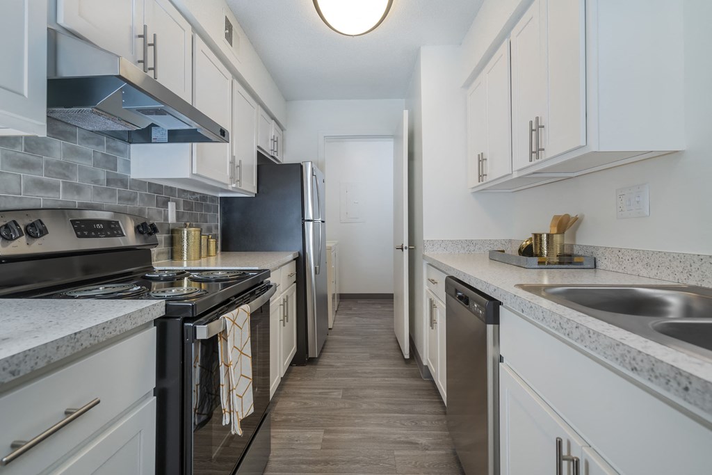 a kitchen with white cabinets and a black stove and a refrigerator