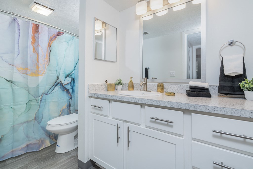 a bathroom with a shower and a sink and a toilet
