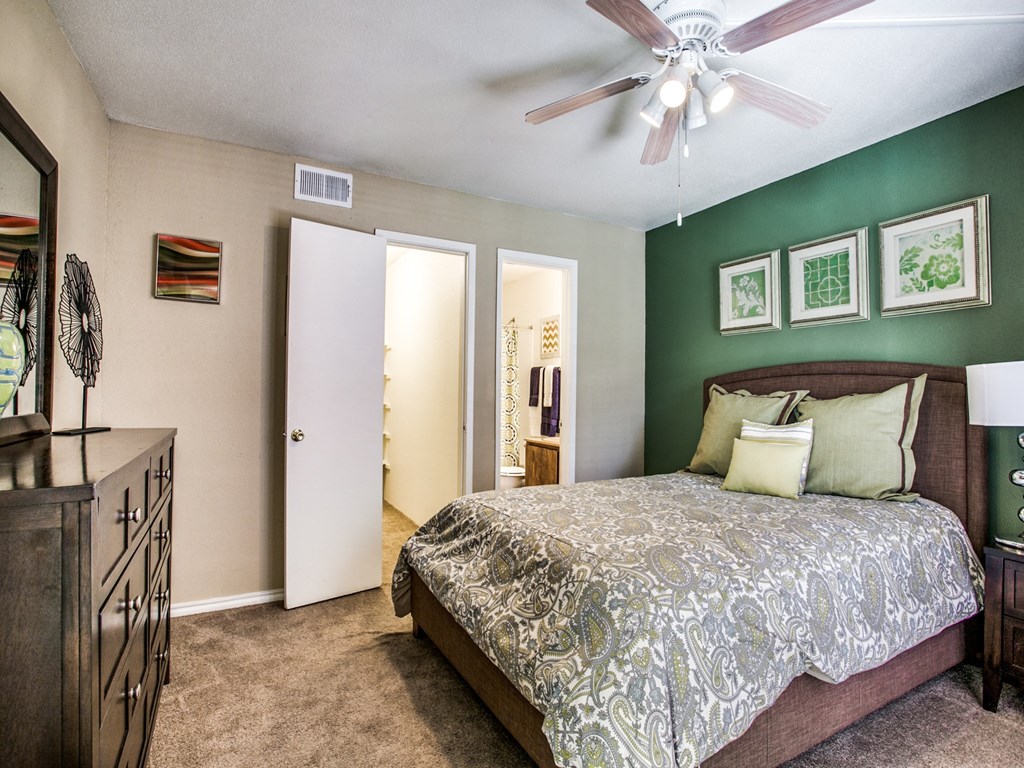 a bedroom with a large bed and a ceiling fan