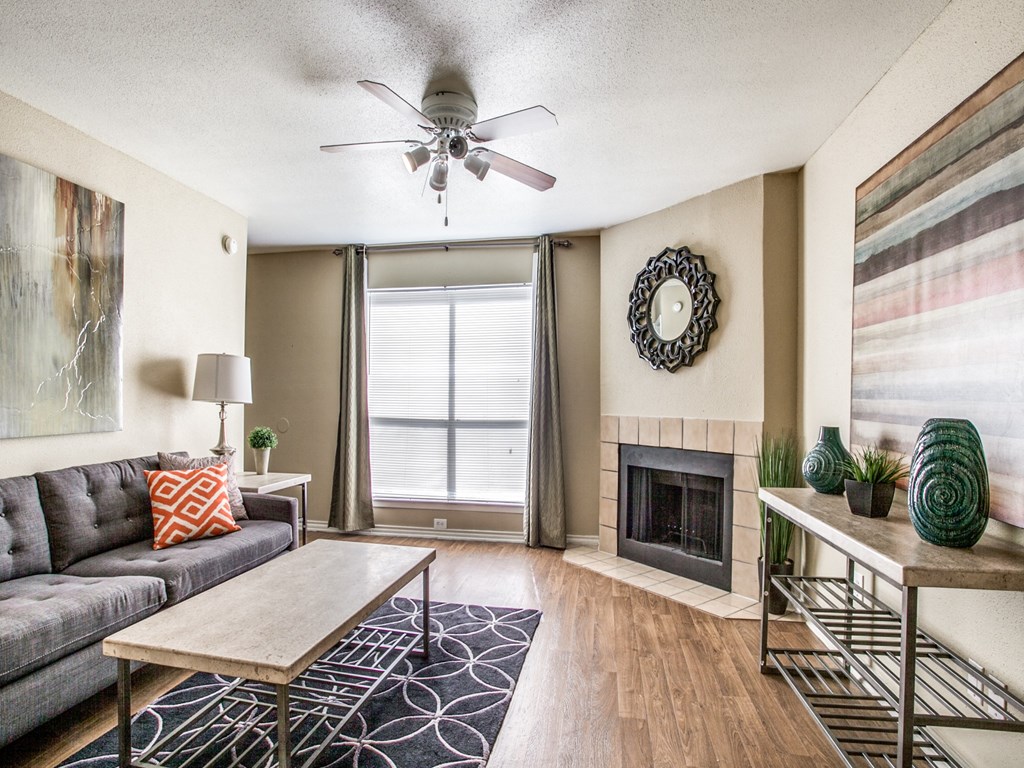a living room with a ceiling fan and a fireplace