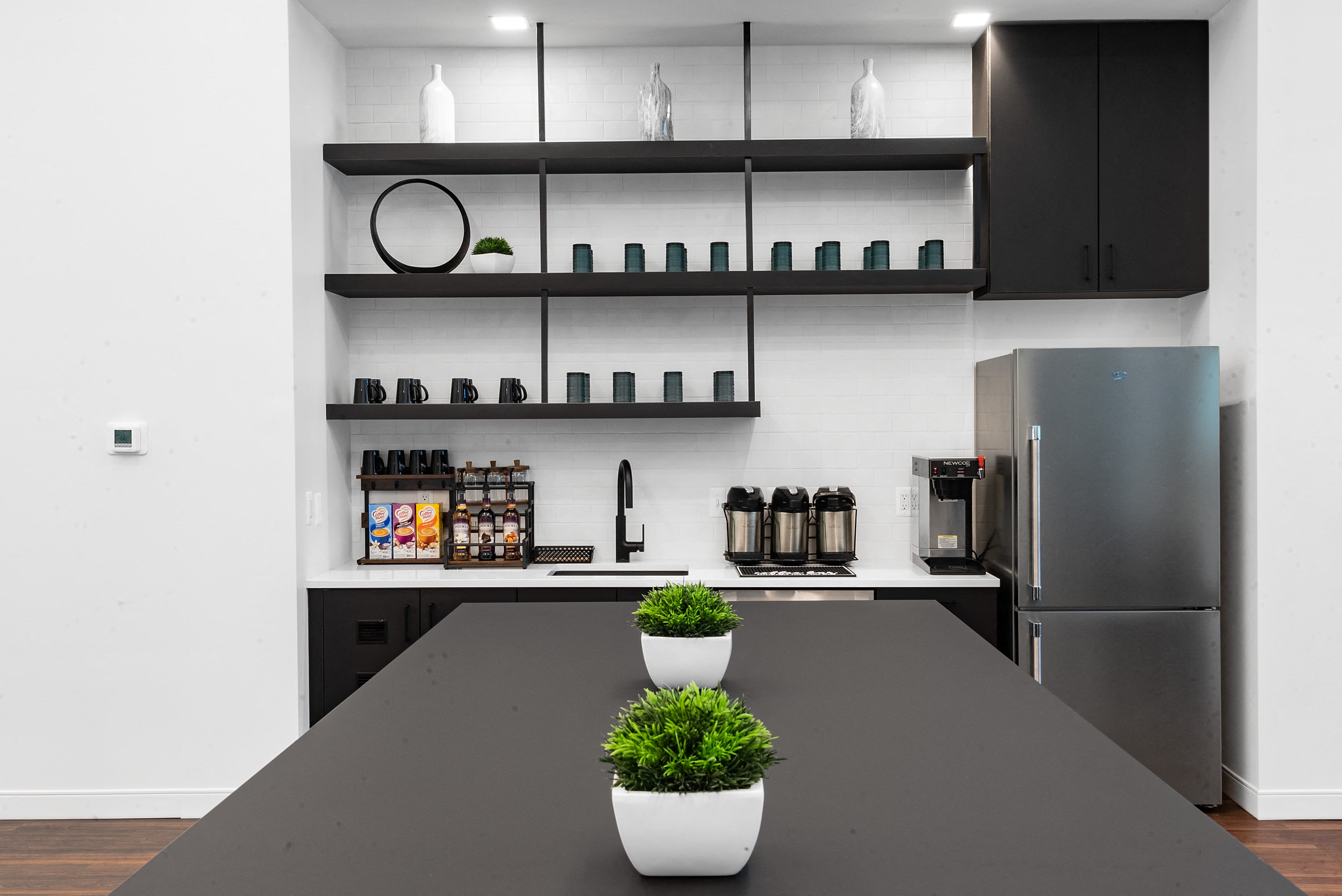 a kitchen with a large black table and a refrigerator