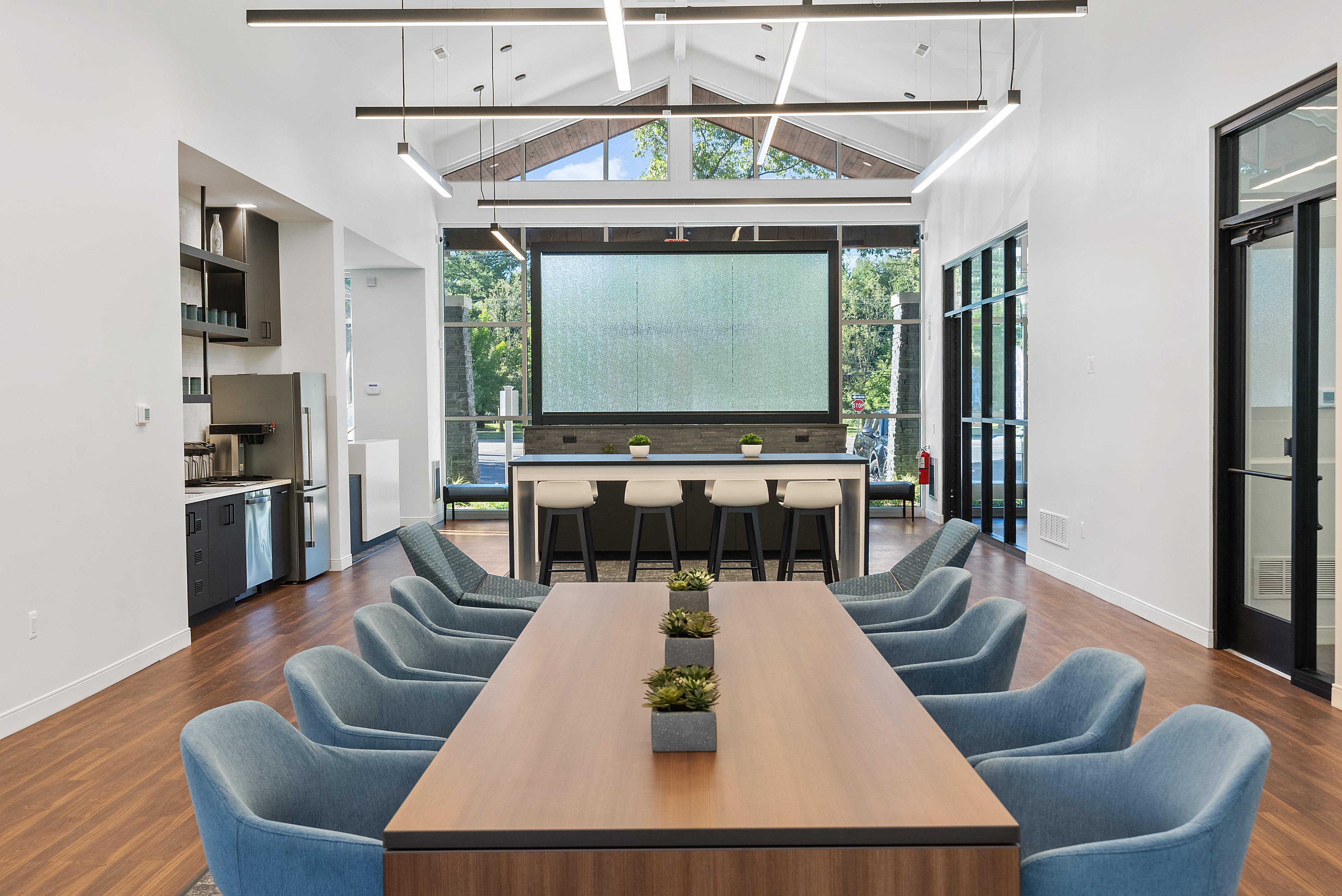 a conference room with a large table and chairs and a chalkboard in the middle