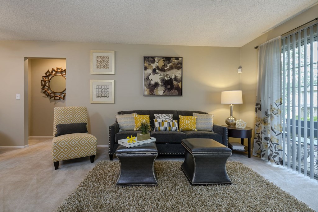 a living room with a couch and chairs and a window