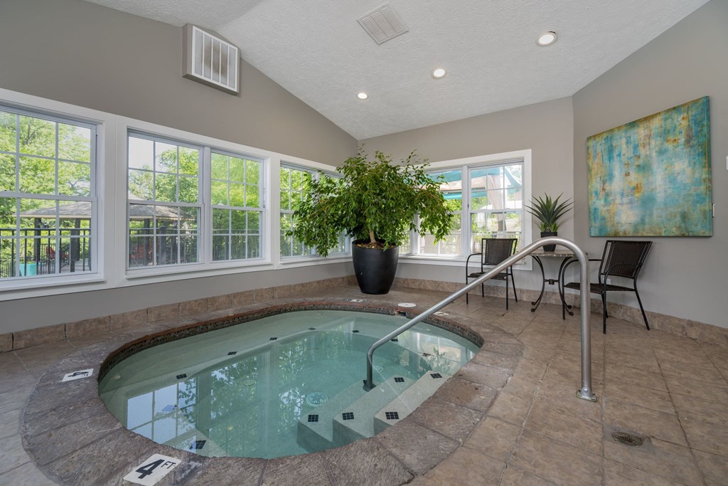a spa with a hot tub and a table with chairs