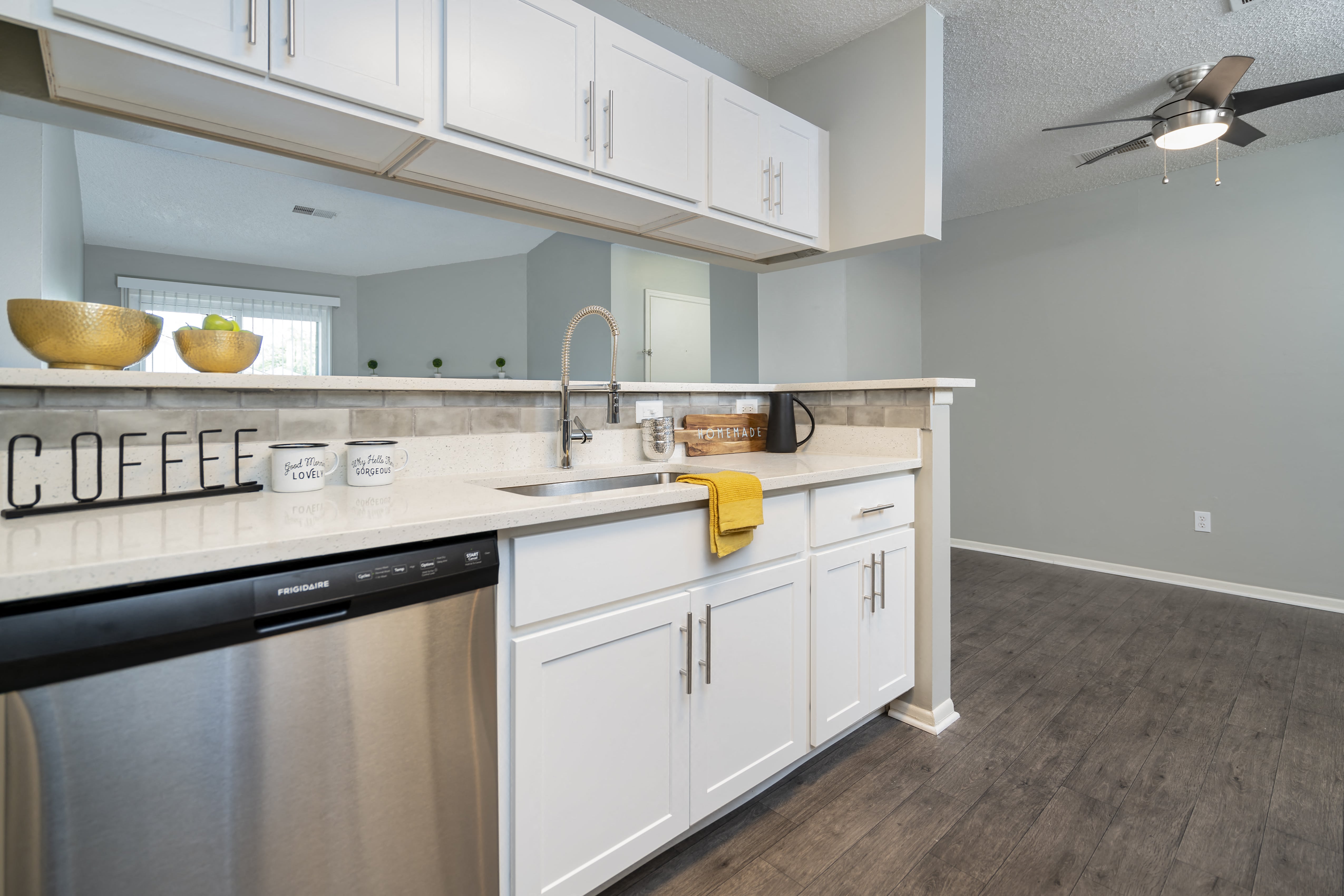 a kitchen with white cabinets and a dishwasher and a sink