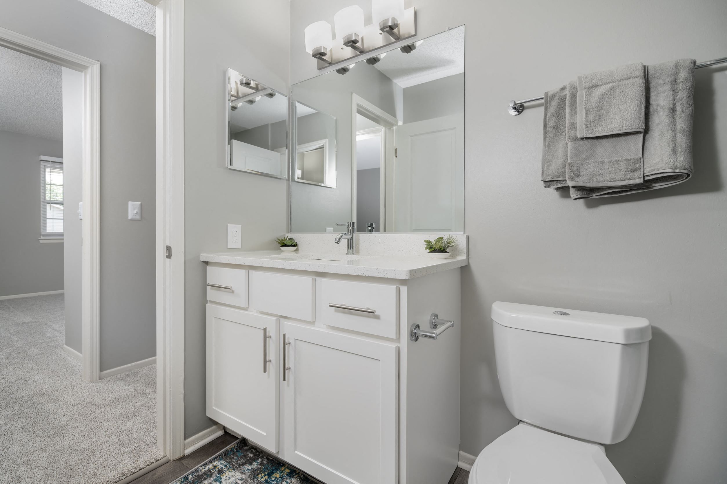 a white bathroom with a white toilet and a sink