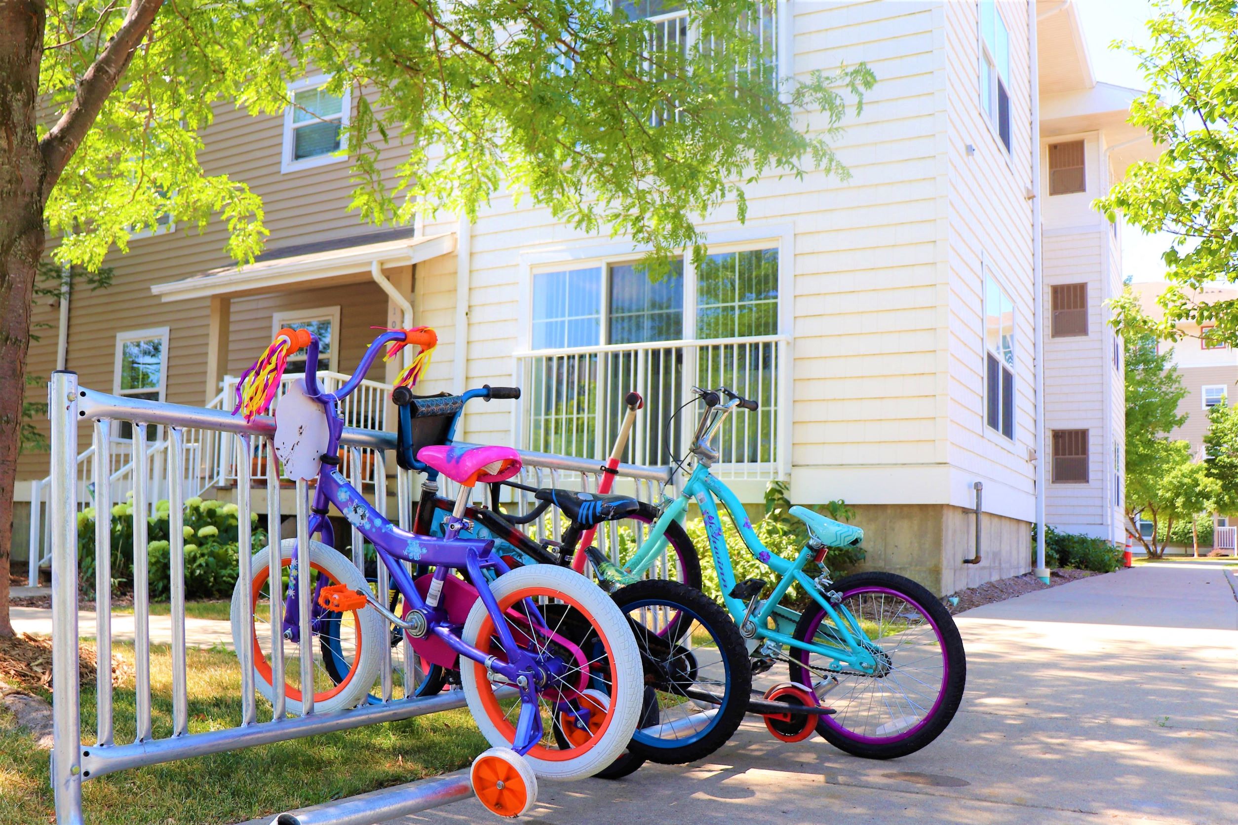 a group of bikes parked on a fence in front of a house