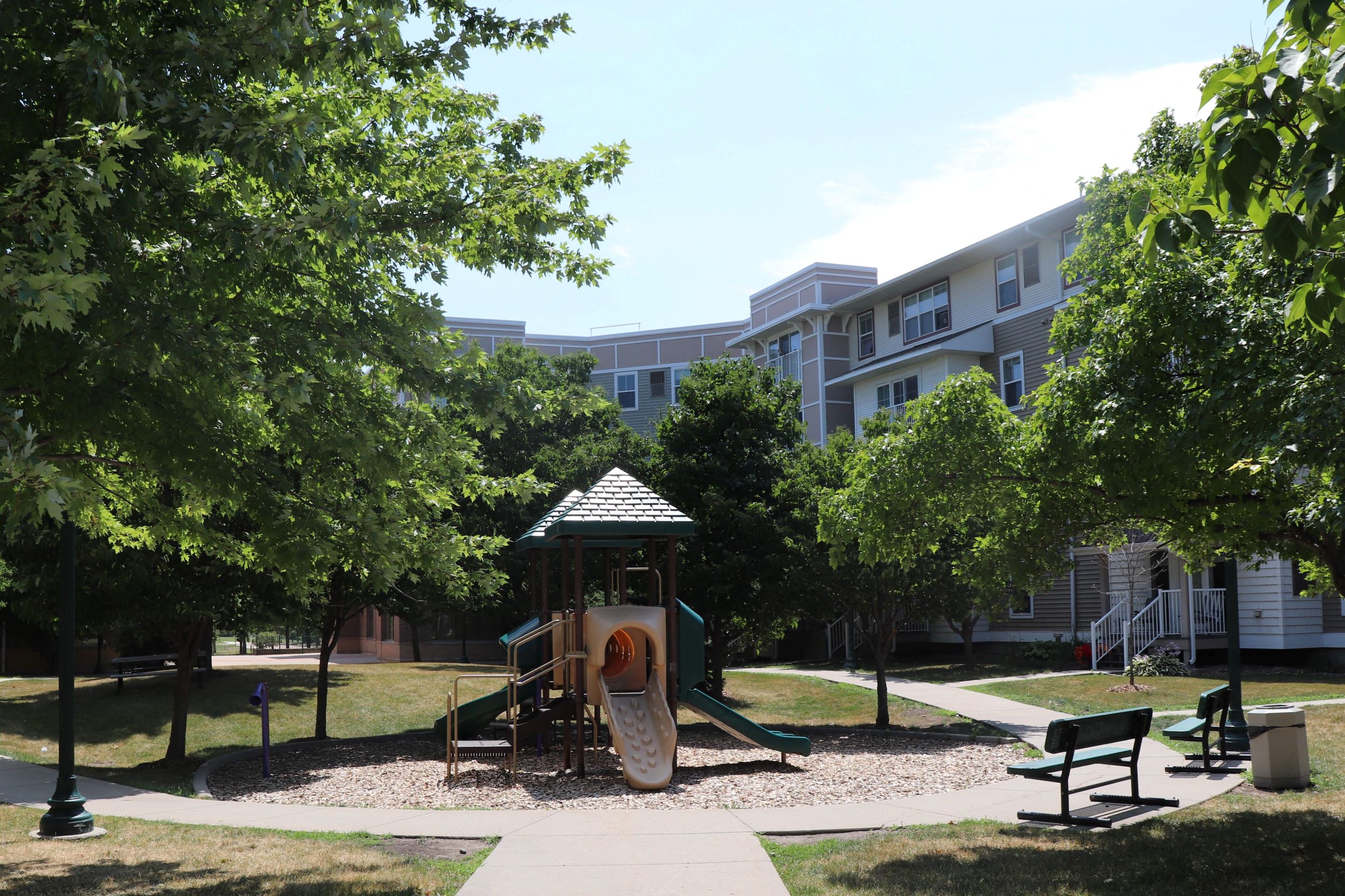 a playground in a park in front of an apartment building