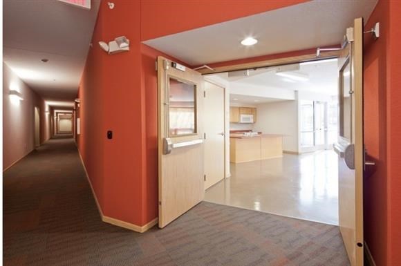 a hallway with an open door and a kitchen