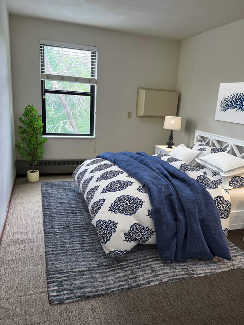 a blue and white bedroom with a bed and a window