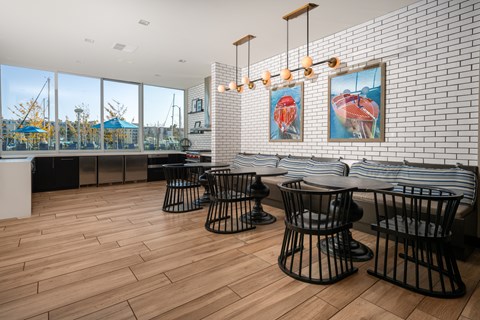 A room with a white brick wall and black chairs.
