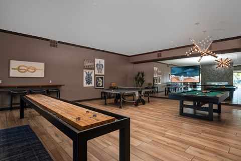 A room with a pool table and a shelf with various items on it.