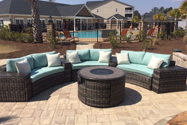 an outdoor patio with couches and a fire pit