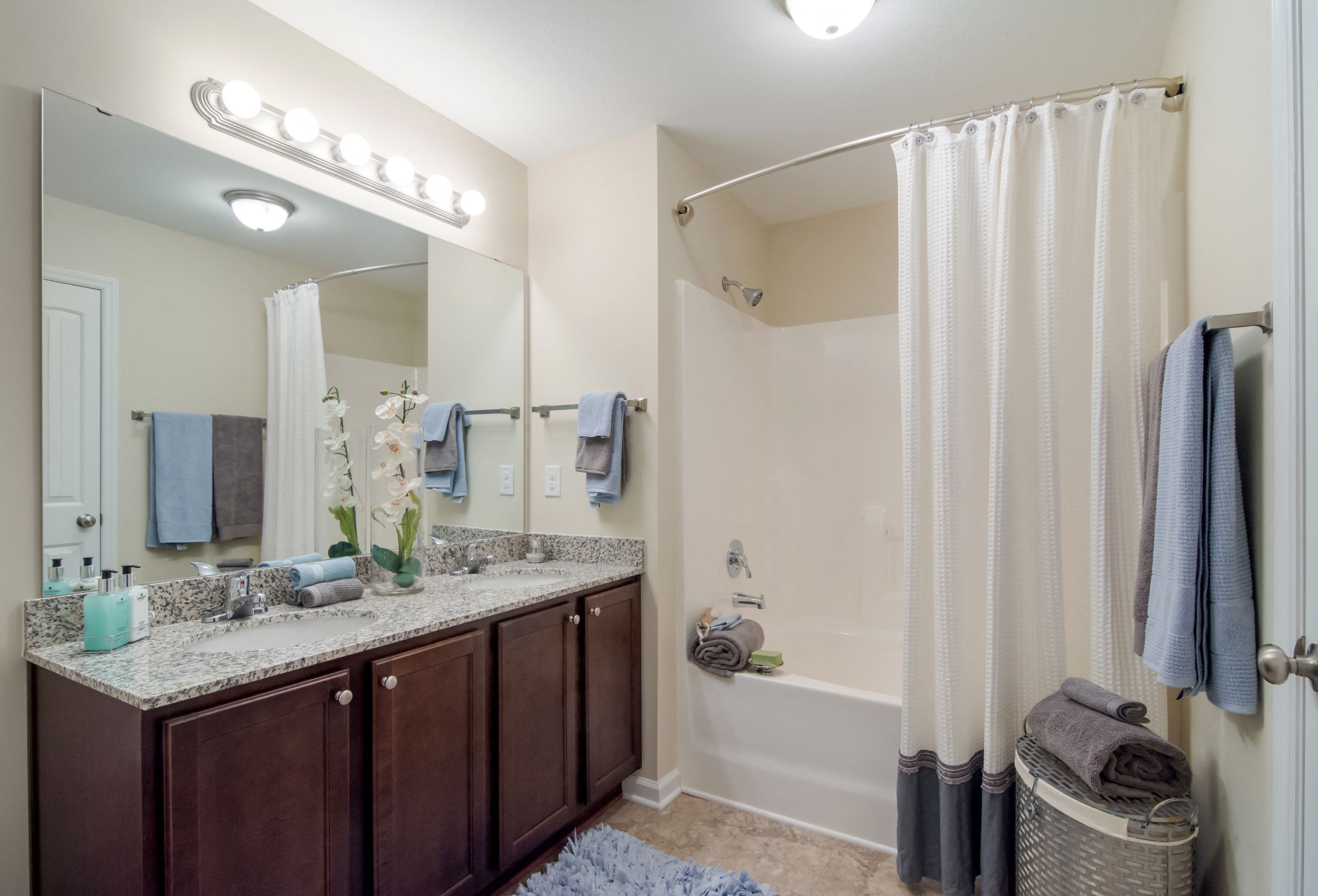 a bathroom with a shower and a sink and a mirror