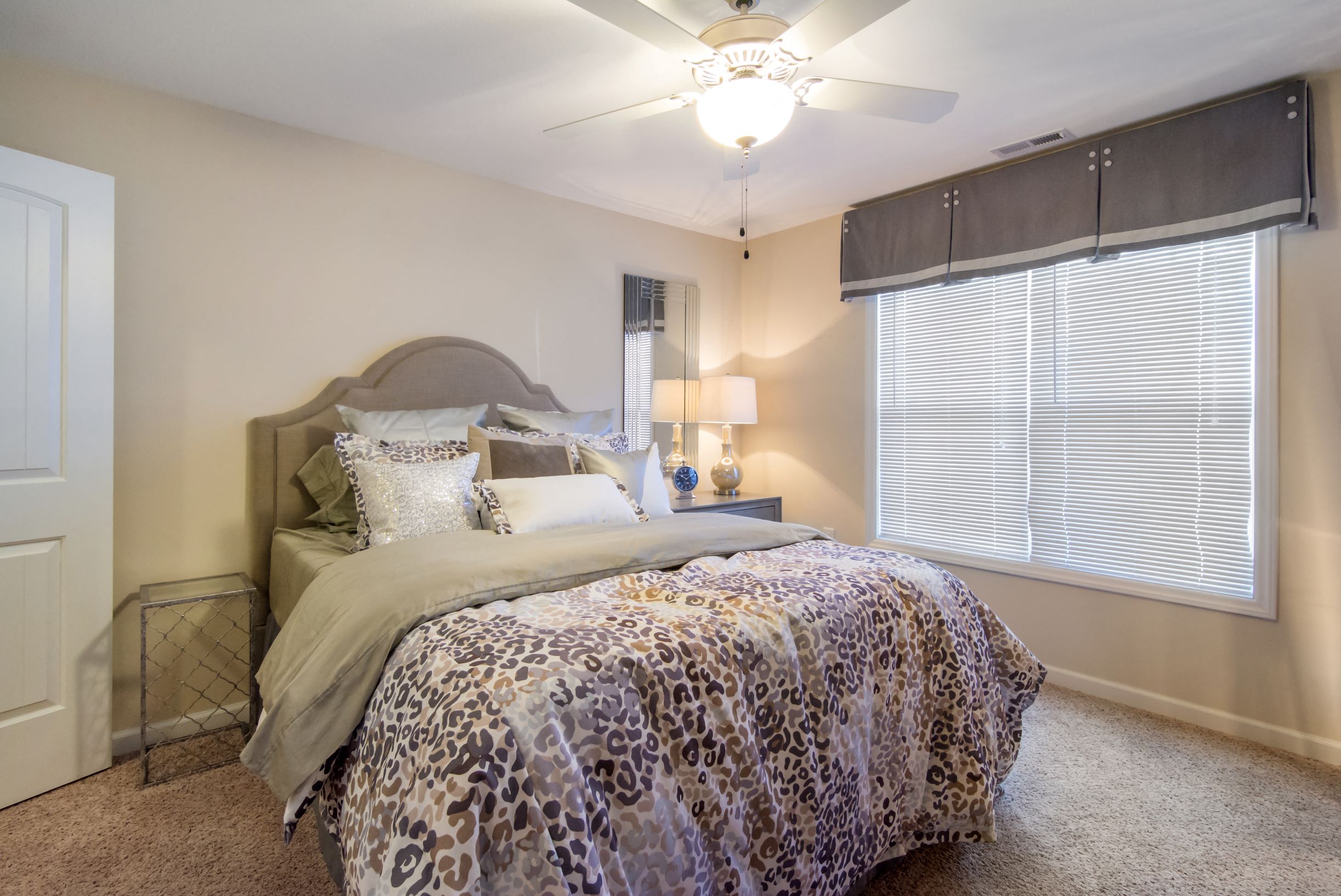 a bedroom with a bed and a ceiling fan