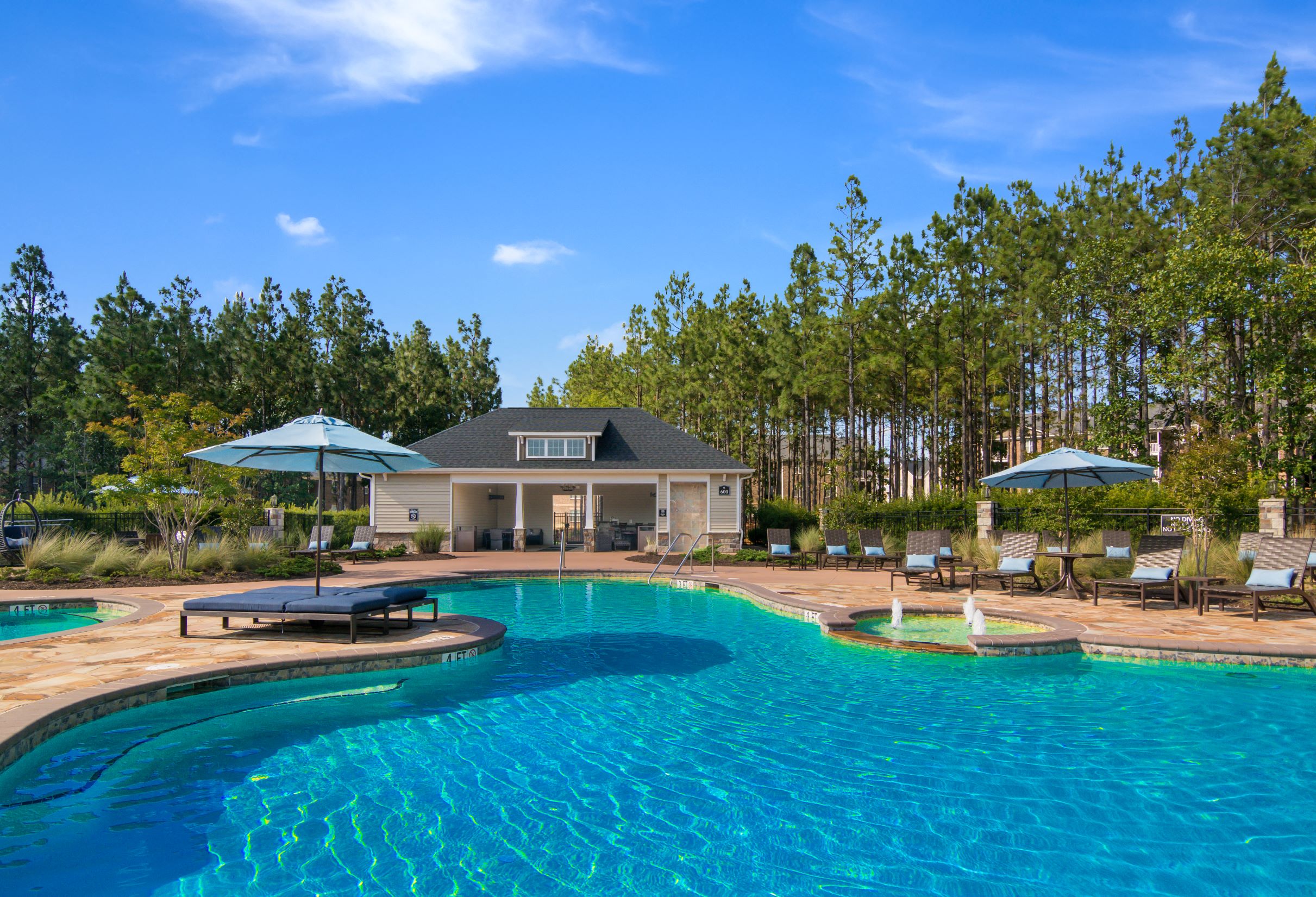 a large swimming pool with a house in the background