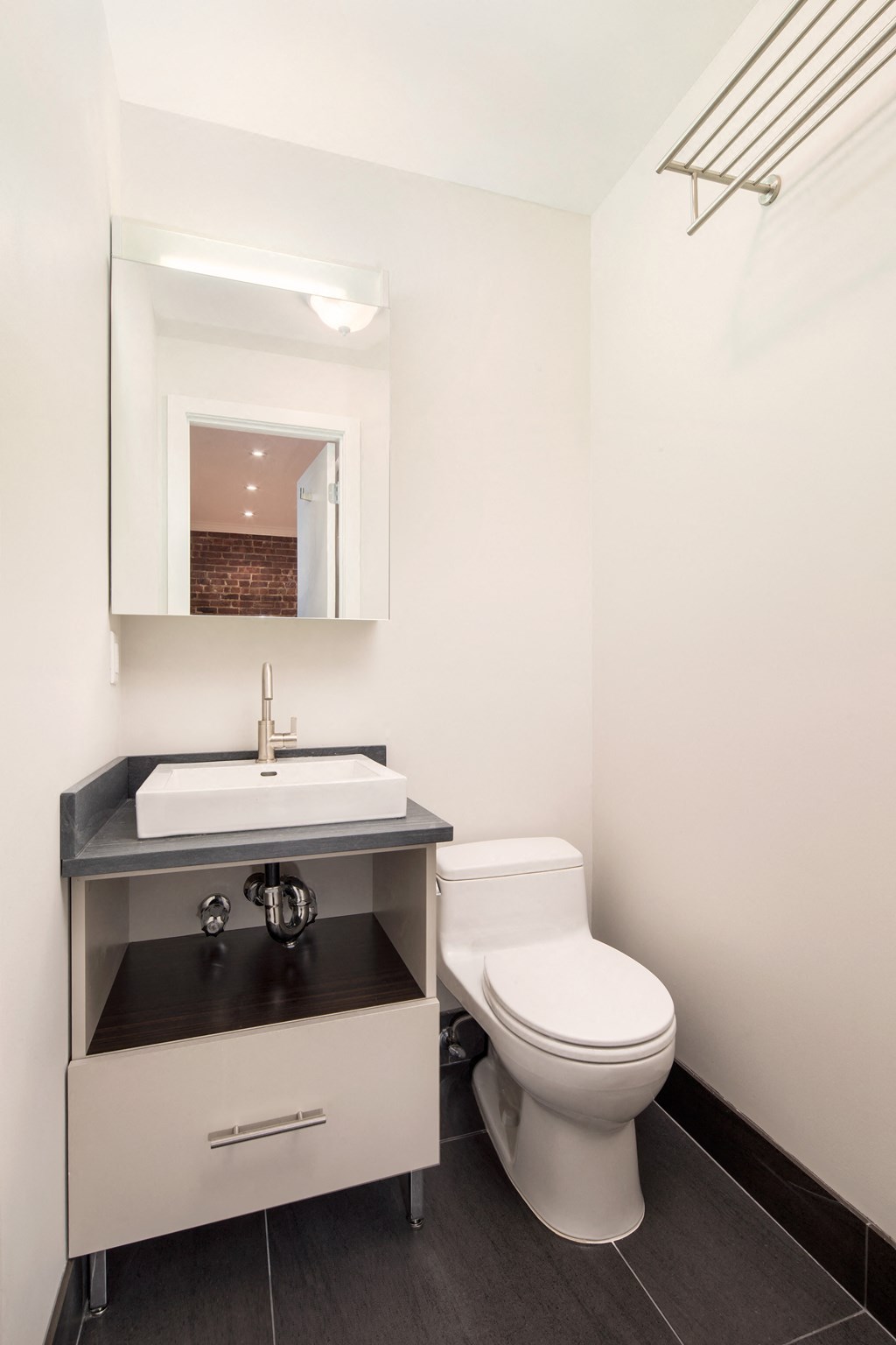 a bathroom with a toilet sink and a mirror