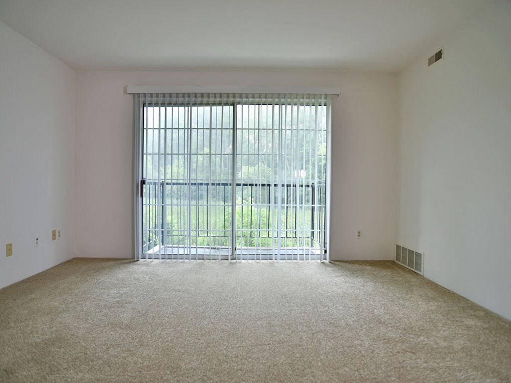 Living Room With Balcony Access at Charter Oaks Apartments, Davison, MI