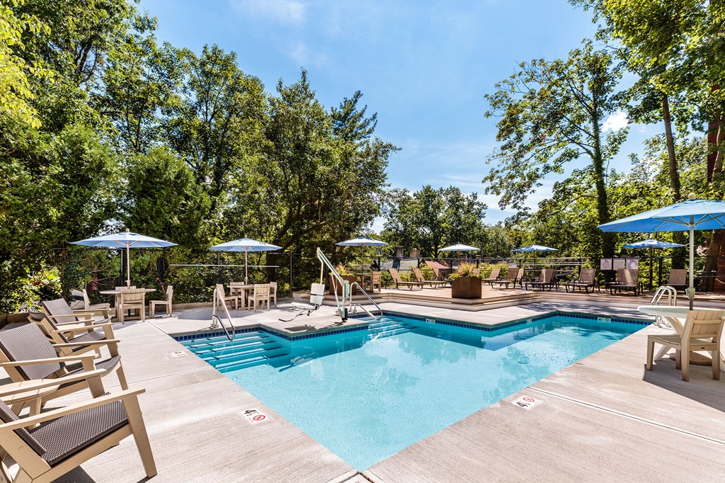 a swimming pool with chairs and umbrellas at the resort