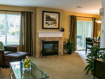 Cozy Gas Fireplace with Mantle in Spacious Living Room with Carpeting at Vancouver WA Apartments Near Vanport