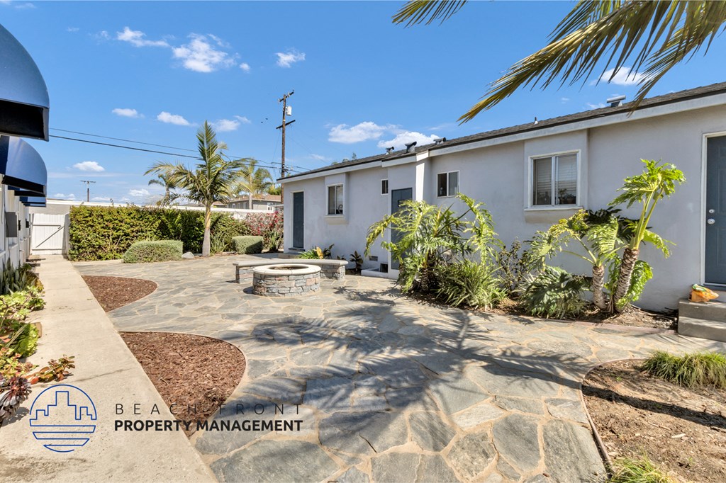 a white house with a patio and a fire pit