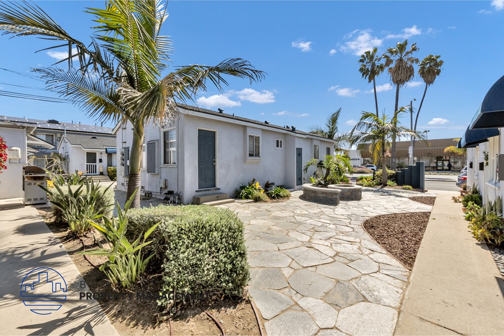 a house with a pathway and palm trees in front of it
