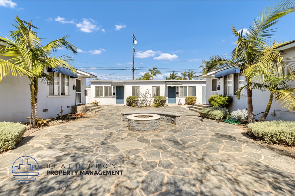 a courtyard with palm trees in front of a house