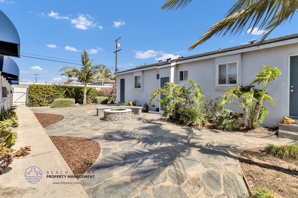 a white house with a patio and a fire pit