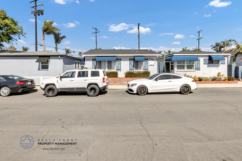 two cars parked in a parking lot in front of houses