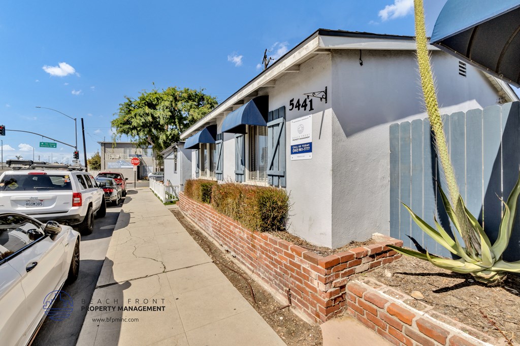 the side of a building with cars parked on the street