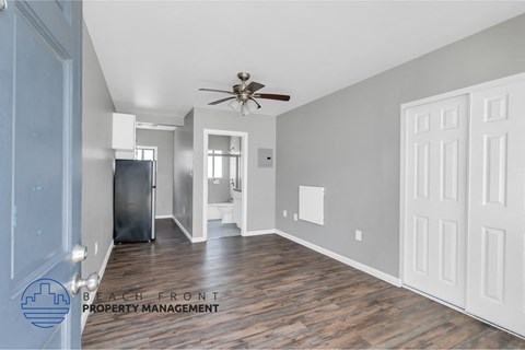 a renovated living room with wood flooring and a ceiling fan