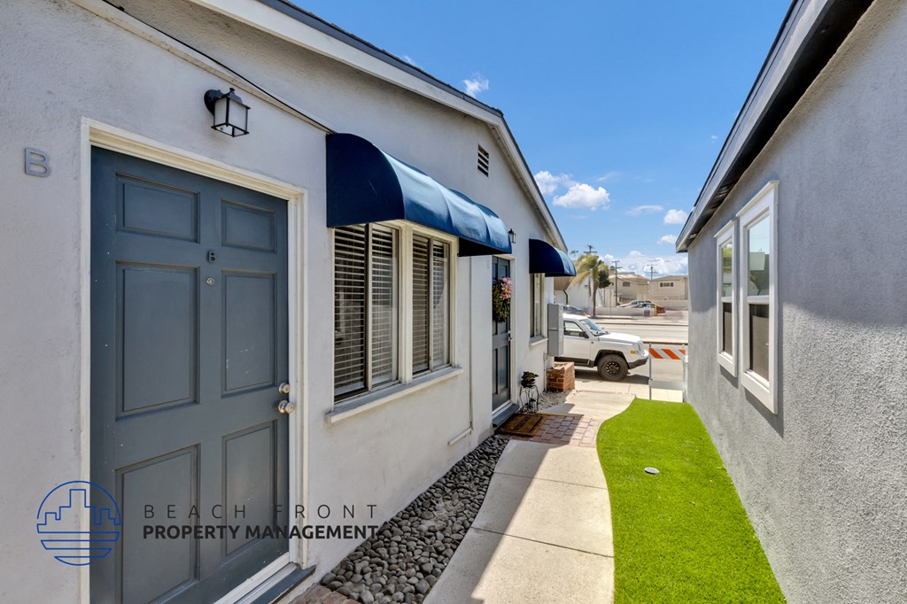 a side view of a building with a blue door and a lawn