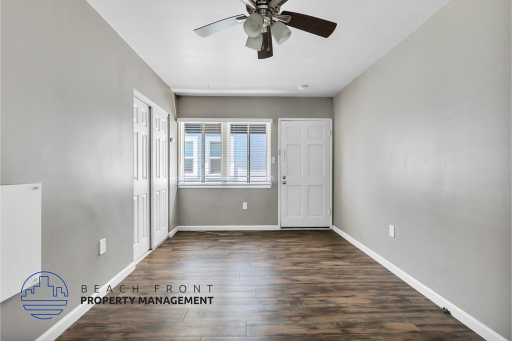 an empty room with a ceiling fan and a window
