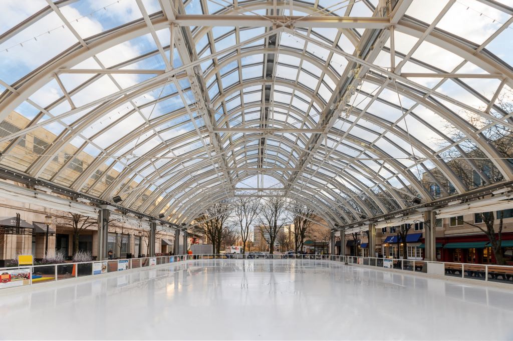 an empty indoor ice rink is seen in the middle of a mall