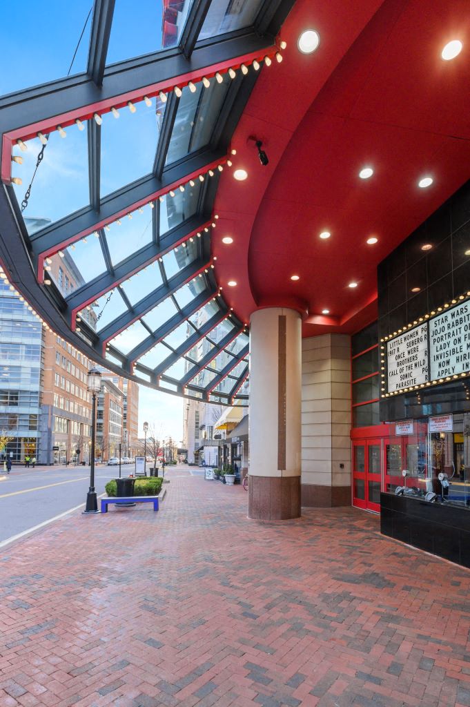 a building with a red roof and a blue bench in front of it