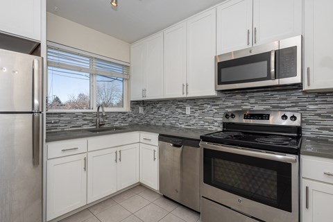 a kitchen with stainless steel appliances and white cabinets