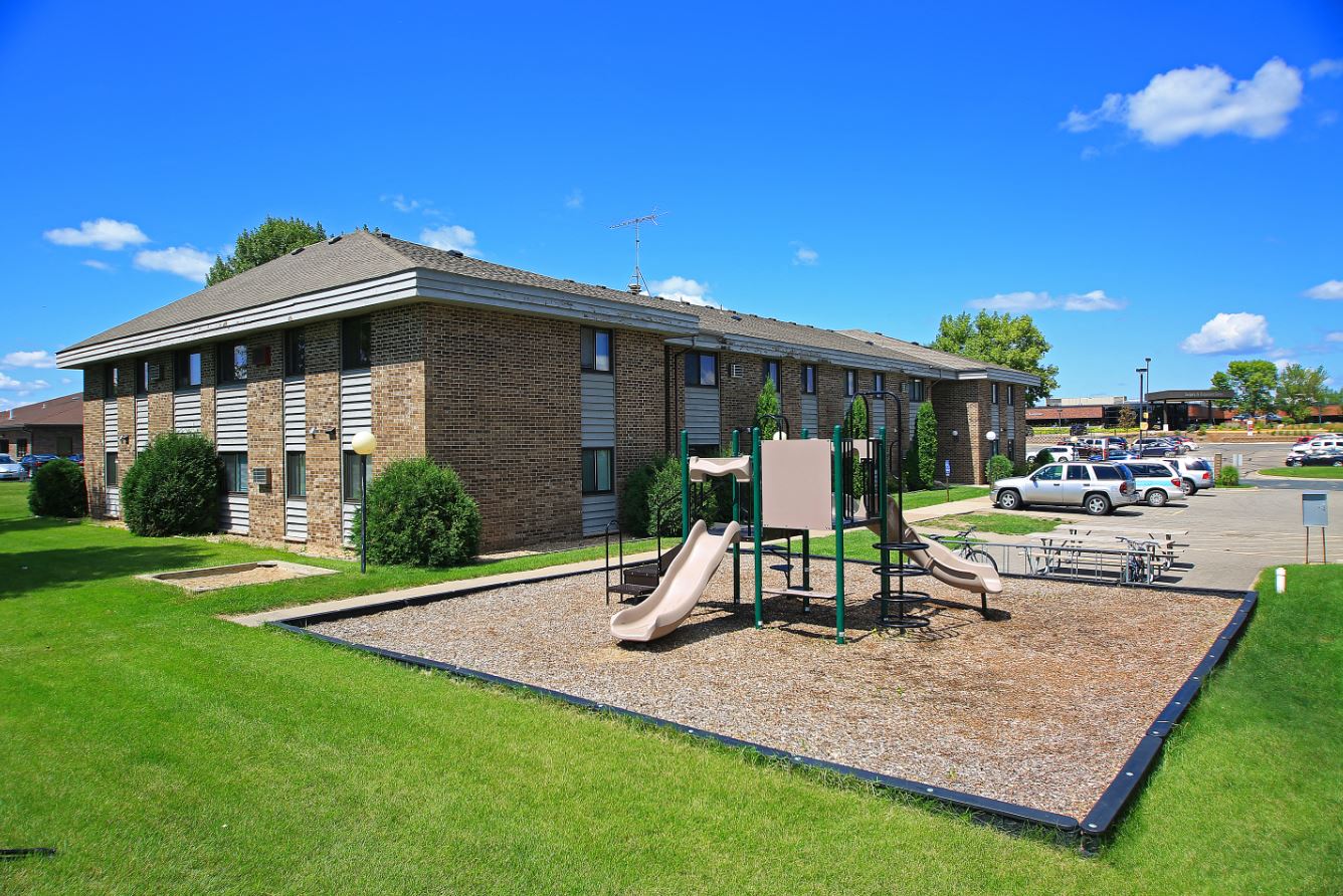 a playground in front of a brick building