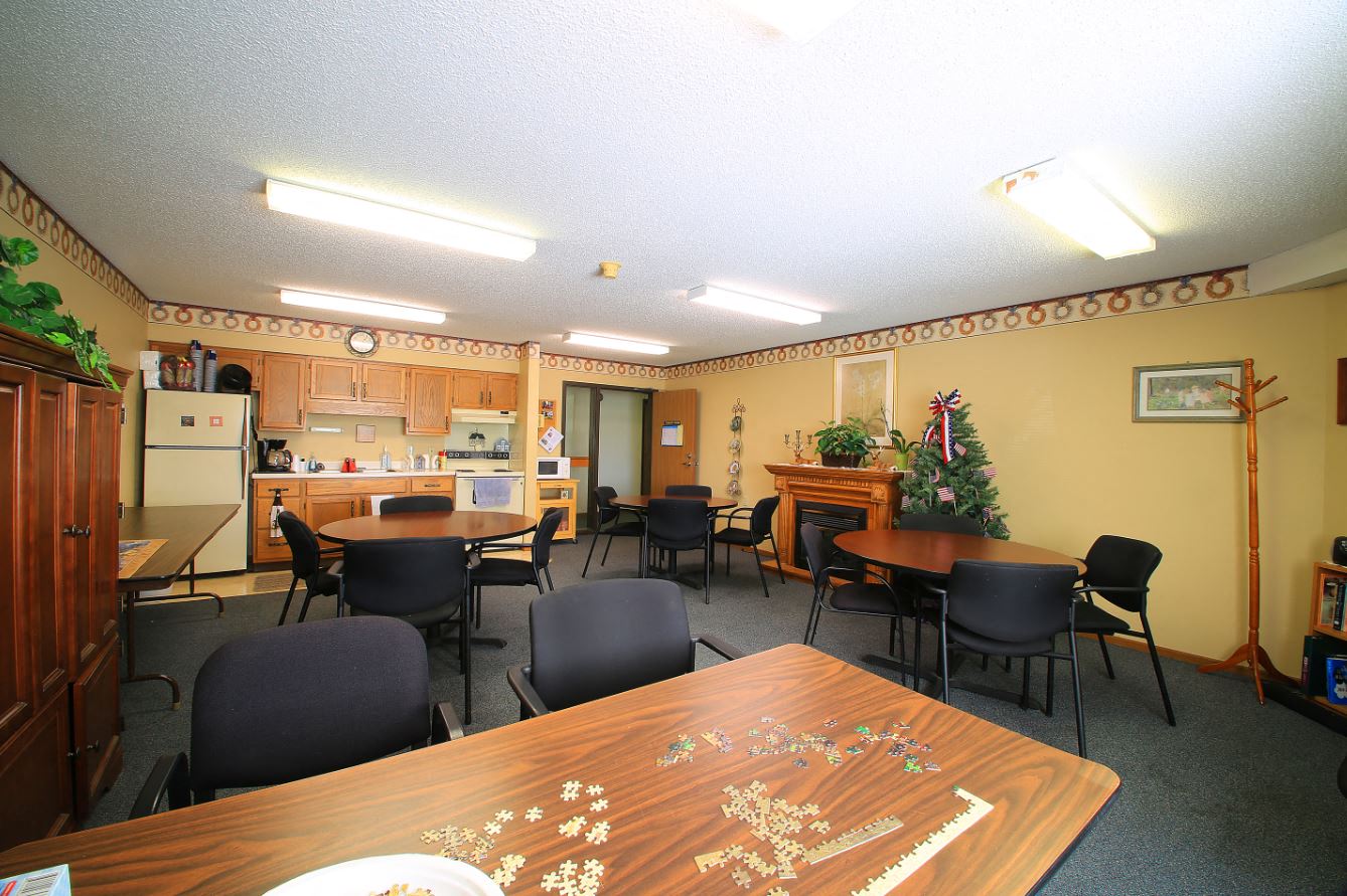 a dining room with tables and chairs and a kitchen