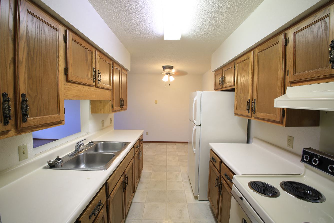 a kitchen with white appliances and wooden cabinets